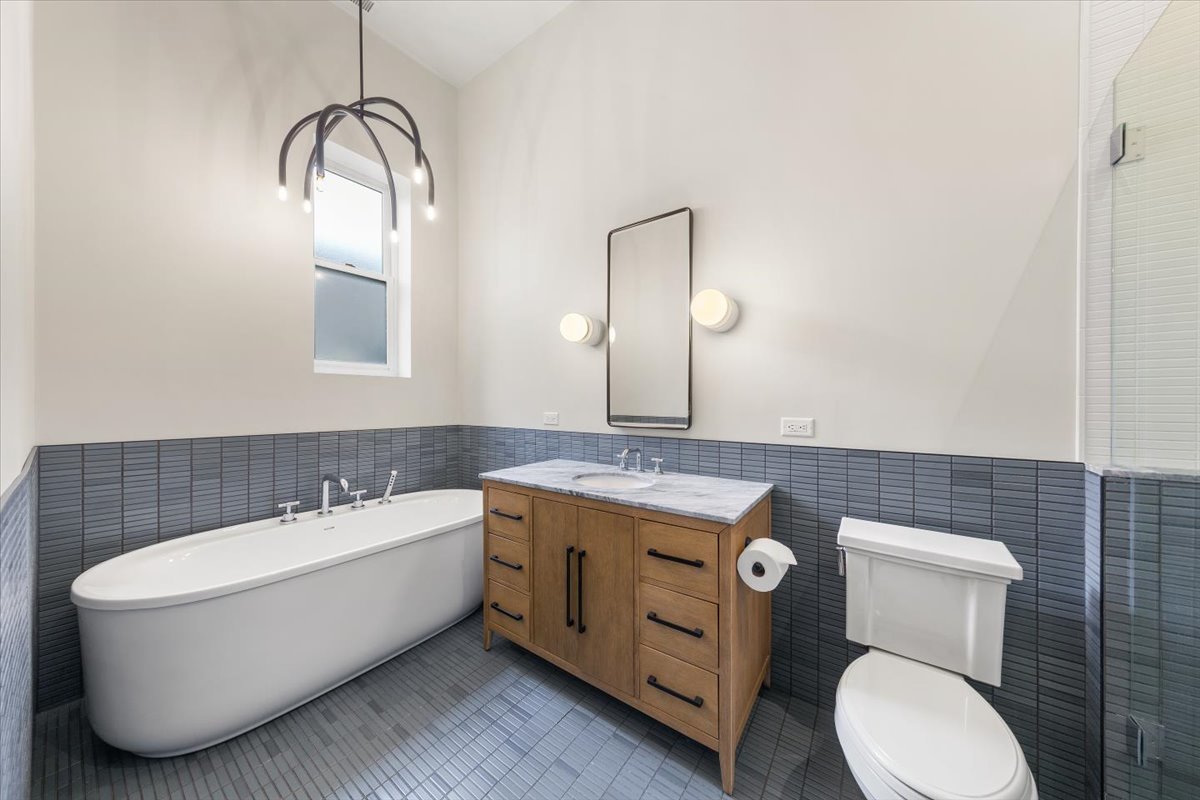 2849 North Burling Street, Unit 3 Chicago, IL 60657 - Photo 15 of 18 a bathroom with a granite countertop toilet a sink and mirror