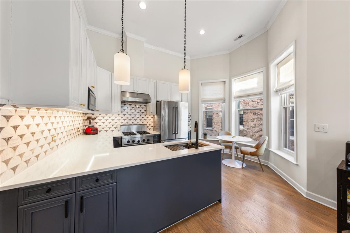 2849 North Burling Street, Unit 3 Chicago, IL 60657 - Photo 6 of 18 a kitchen with a sink stove and wooden floor