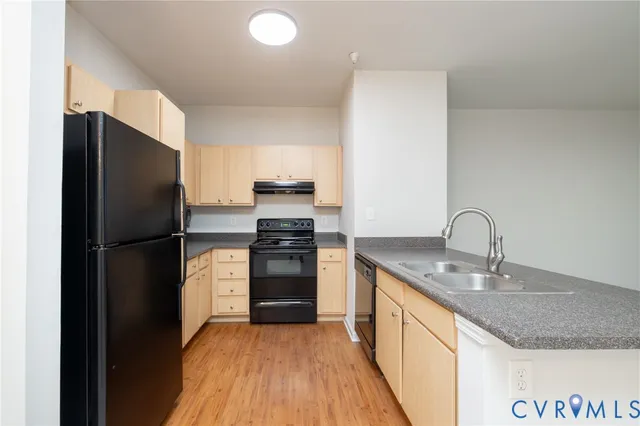 a kitchen with granite countertop a refrigerator and a sink