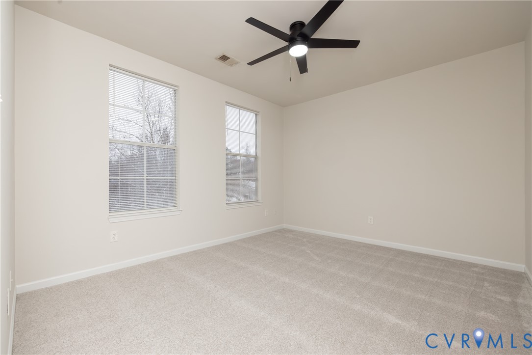 734 Bristol Village Drive, Unit 208 Midlothian, VA 23114 - Photo 19 of 24 an empty room with chandelier fan and windows