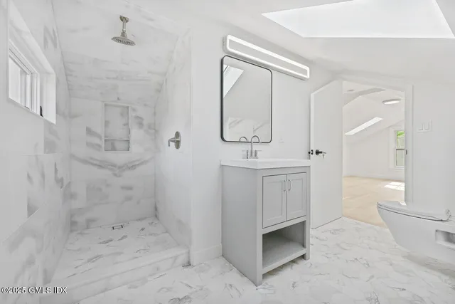 a bathroom with a sink a toilet and shower