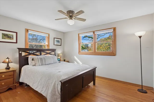 a bedroom with bed painting on the wall and a large window