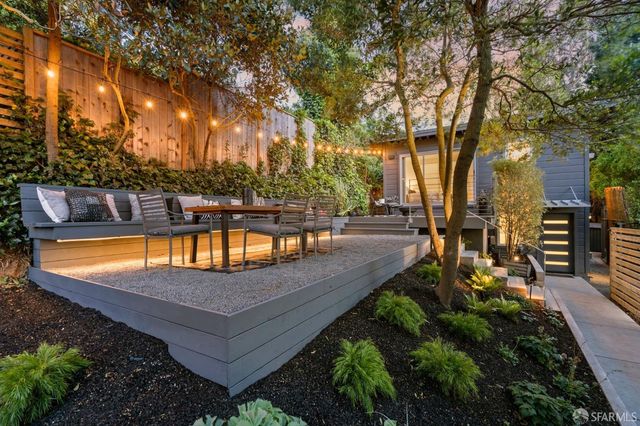 a view of a patio with table and chairs with wooden floor and fence