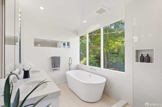 a bathroom with a double vanity sink toilet and a mirror