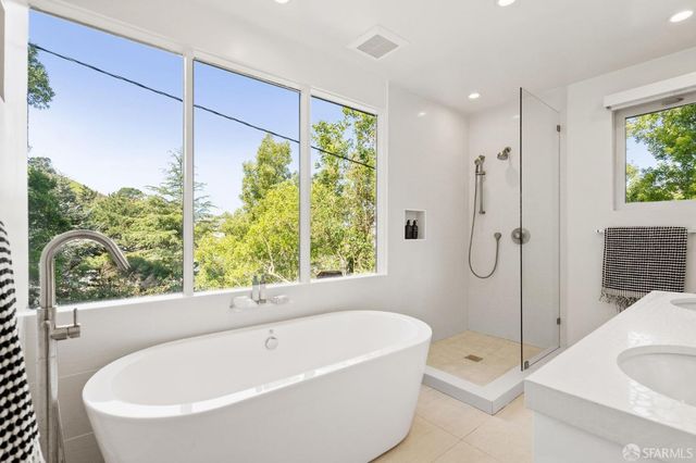 a bathroom with a granite countertop sink a toilet a large mirror and shower