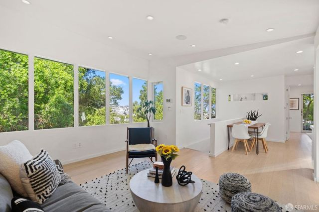 a kitchen with stainless steel appliances granite countertop a refrigerator a sink a stove and white cabinets