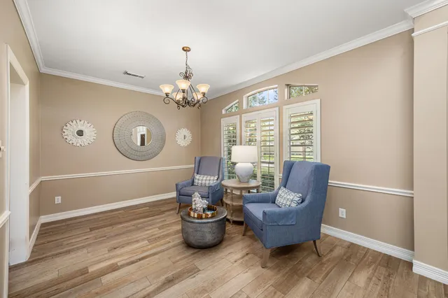 a kitchen with stainless steel appliances granite countertop a refrigerator a stove top oven a sink dishwasher and white cabinets with wooden floor