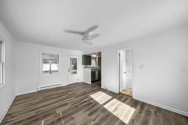 a view of empty room with wooden floor and window