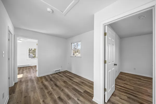 a view of a hallway with wooden floor and entryway