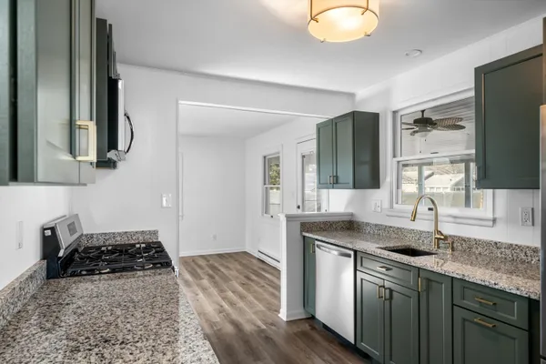 a kitchen with stainless steel appliances granite countertop a sink stove and cabinets