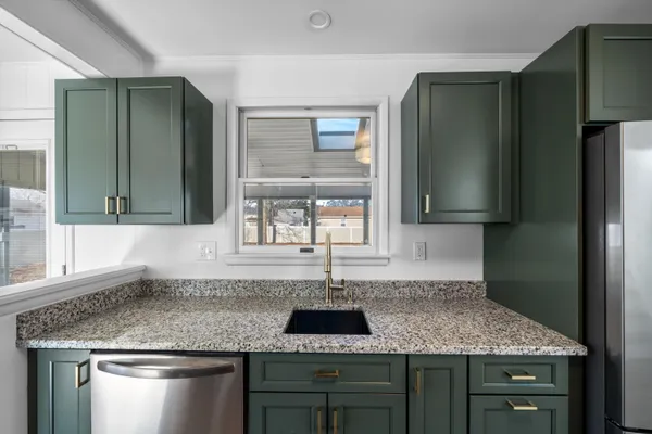 a kitchen with stainless steel appliances granite countertop a sink and a refrigerator