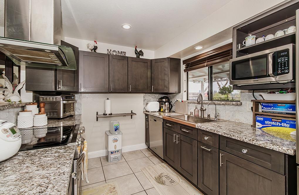 3012 Stanford Avenue Clovis, CA 93611 - Photo 13 of 41 a kitchen with stainless steel appliances granite countertop a sink stove and microwave