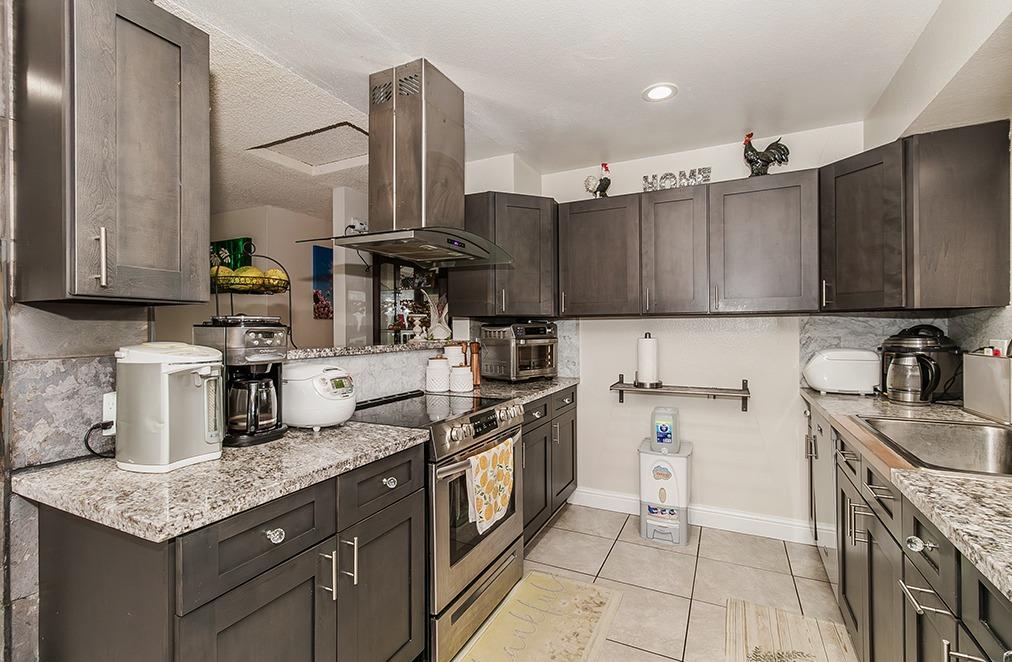 3012 Stanford Avenue Clovis, CA 93611 - Photo 14 of 41 a kitchen with granite countertop a sink a stove and cabinets