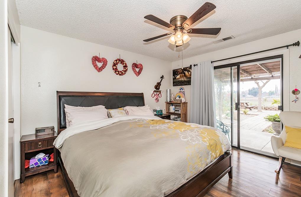 3012 Stanford Avenue Clovis, CA 93611 - Photo 15 of 41 a bedroom with a large bed and a chandelier