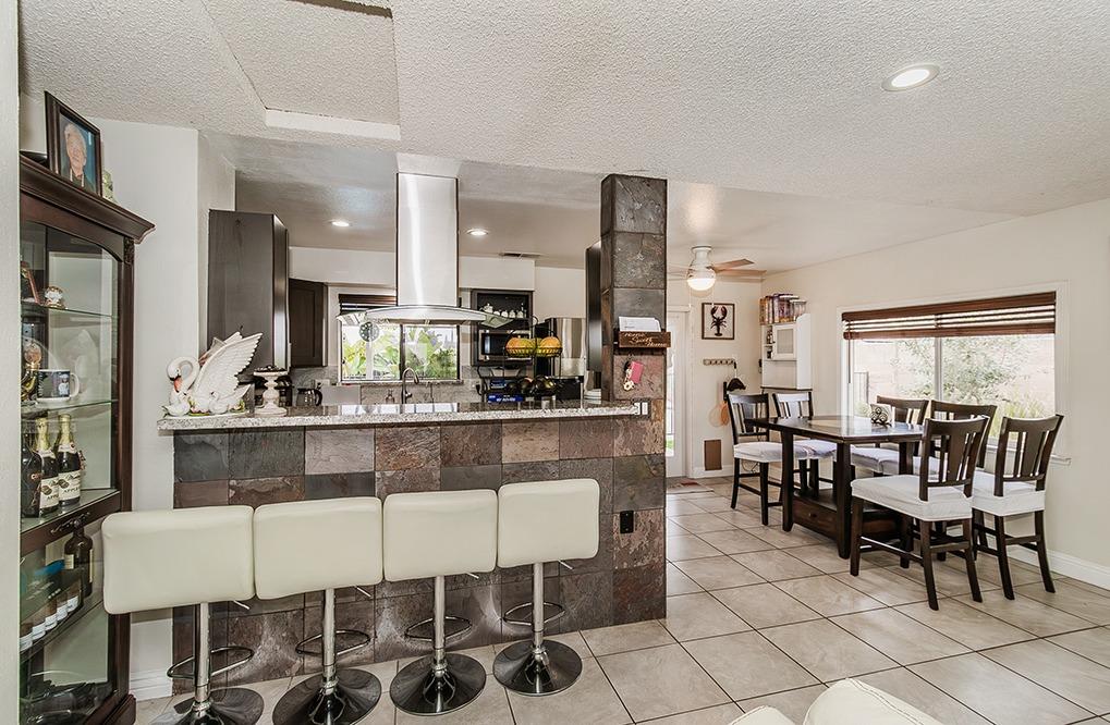3012 Stanford Avenue Clovis, CA 93611 - Photo 10 of 41 a dining hall with stainless steel appliances kitchen island granite countertop a dining table chairs and a sink