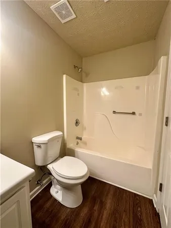 a white toilet sitting next to a bathroom sink and a shower