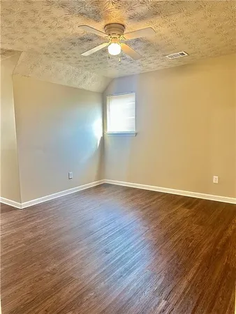 a view of a room with wooden floor and a ceiling fan