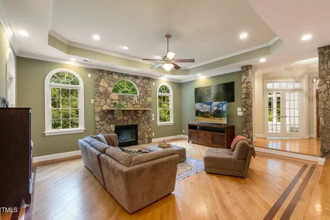 a room with wooden floor pool table and windows