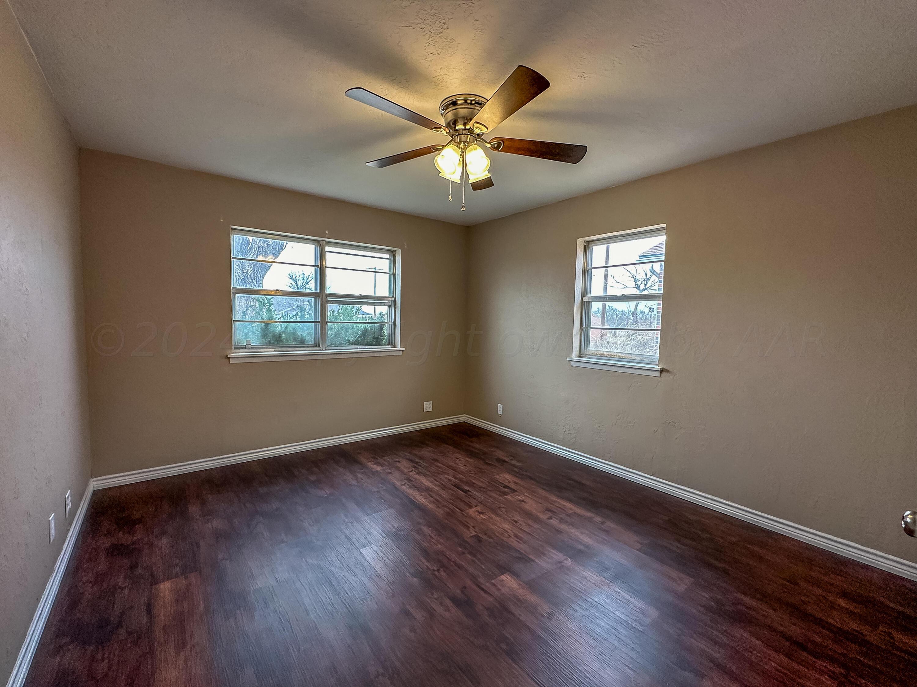 1103 Madison Street Borger, TX 79007 - Photo 12 of 16 a view of an empty room with wooden floor and a window