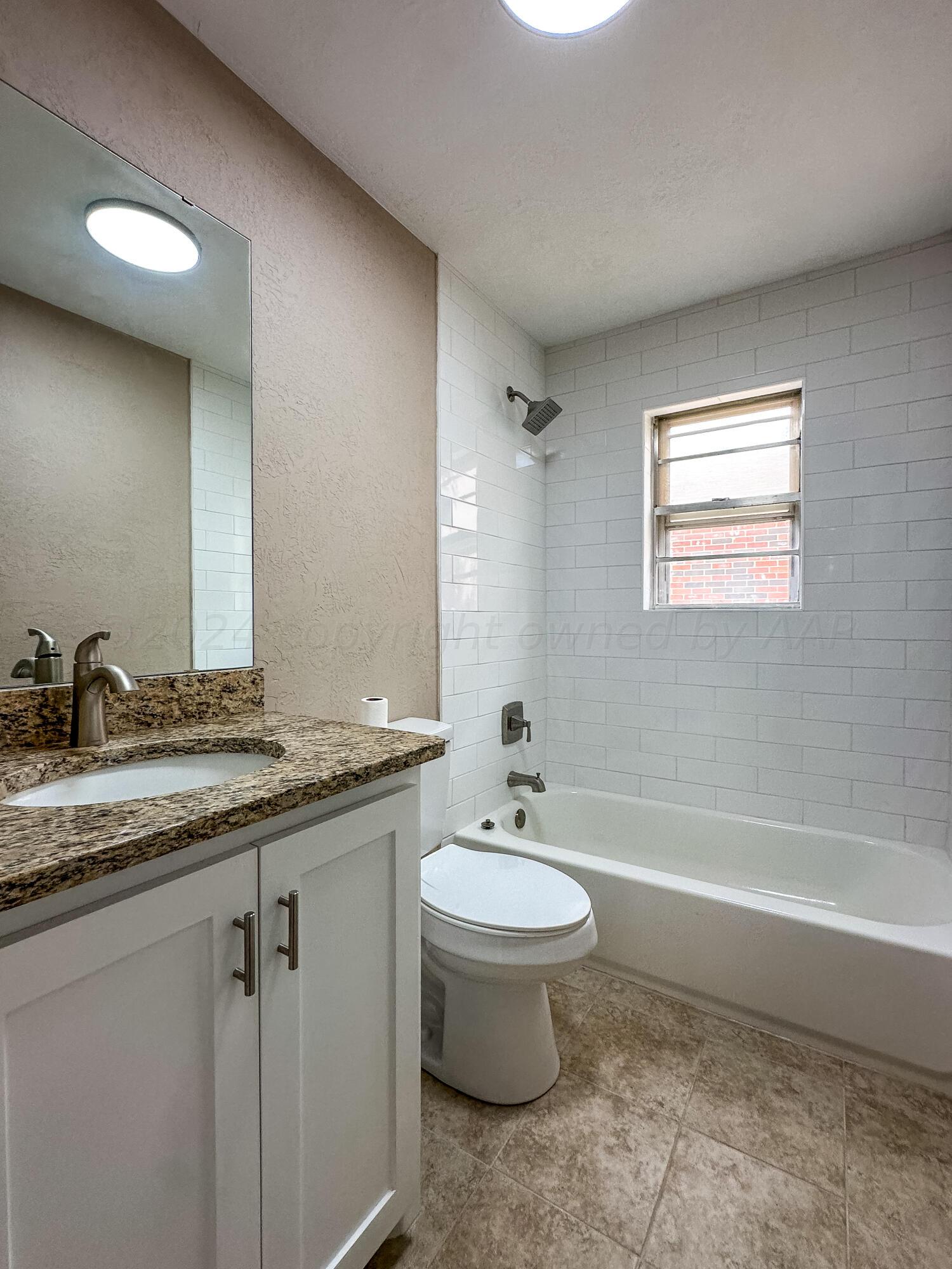 1103 Madison Street Borger, TX 79007 - Photo 10 of 16 a bathroom with a granite countertop sink toilet and bathtub