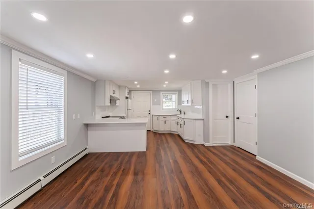 a large kitchen with a lot of counter space and wooden floor