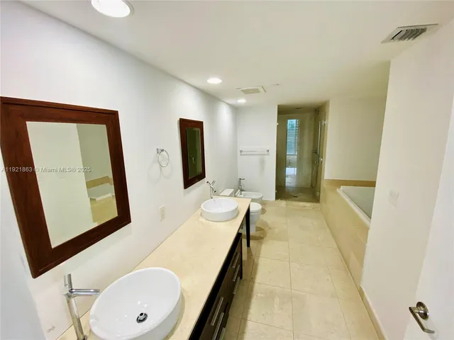 a bathroom with 2 sink tub and a mirror