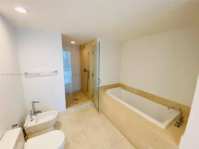 a spacious bathroom with a tub sink and mirror