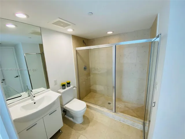 a bathroom with a double vanity sink toilet and shower