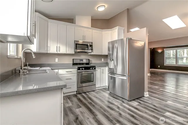 a kitchen with stainless steel appliances a refrigerator sink and microwave
