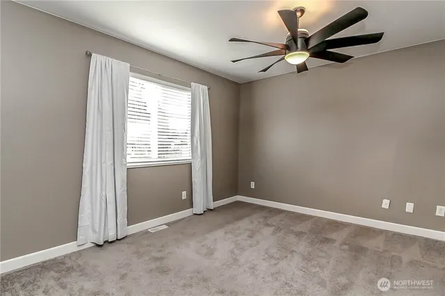 an empty room with a window and a fan