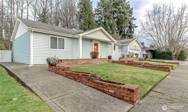 a front view of a house with a garden and trees
