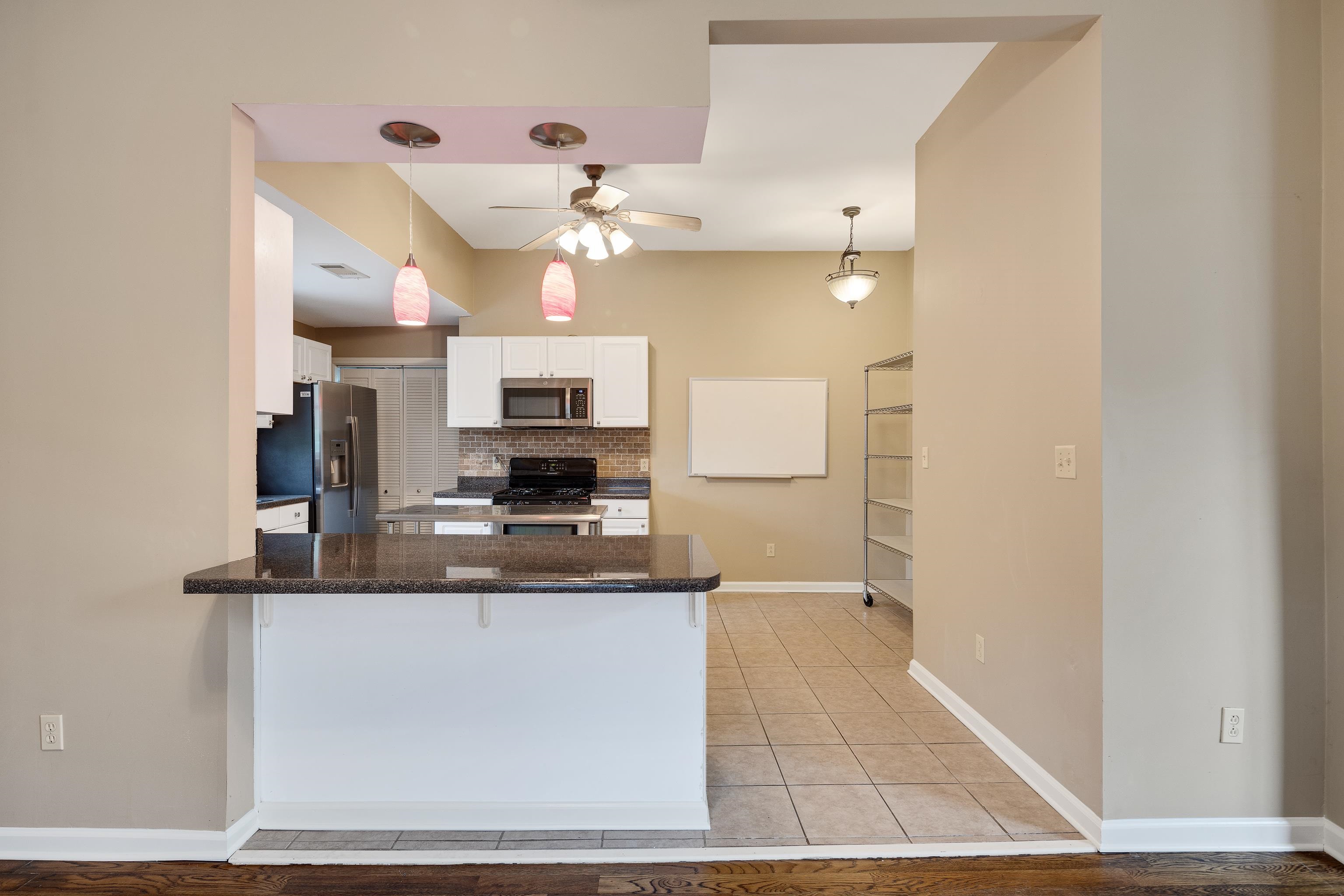1003 New York Street Memphis, TN 38104 - Photo 13 of 40 a kitchen with kitchen island a counter top space appliances and cabinets