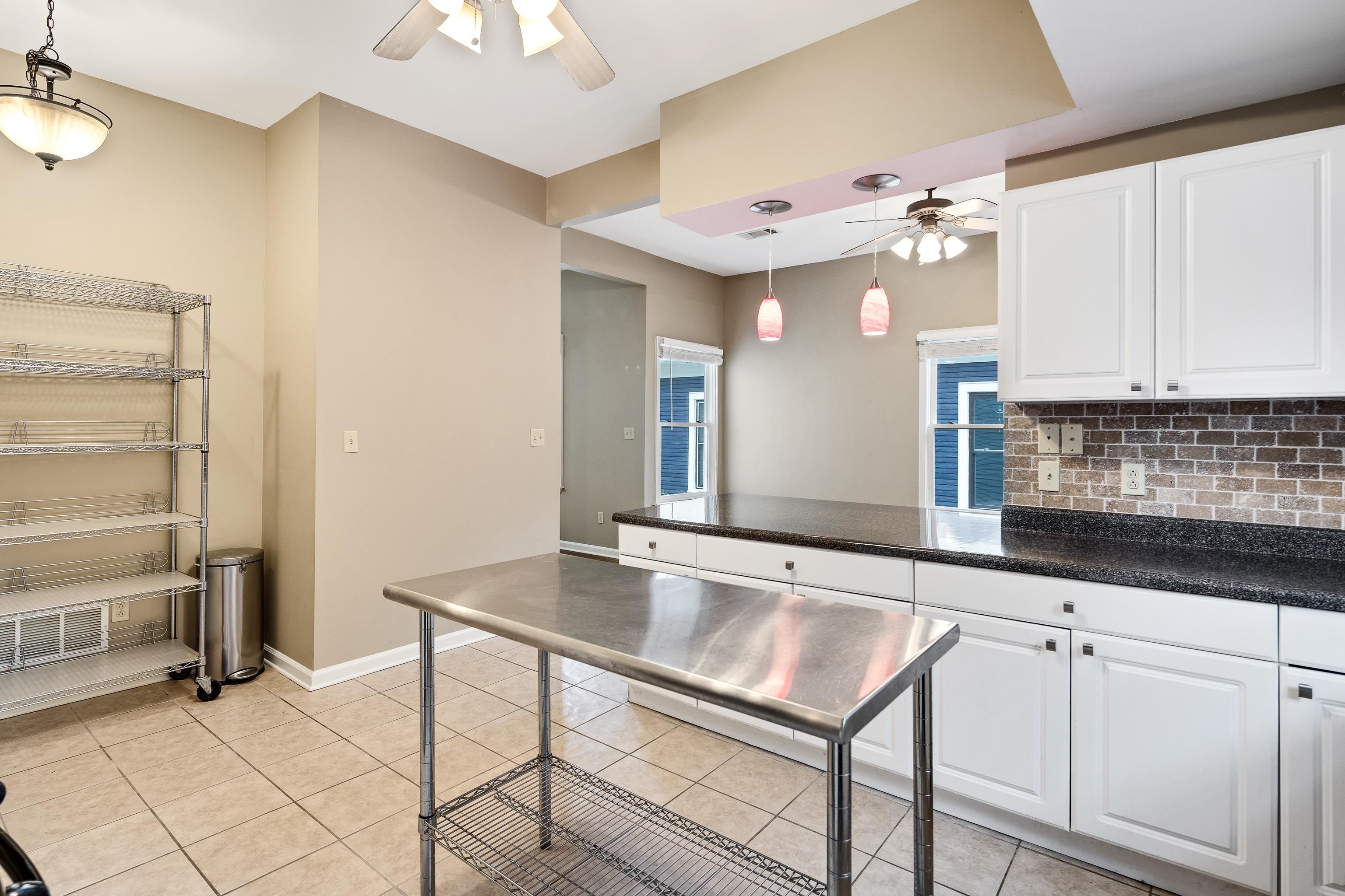 1003 New York Street Memphis, TN 38104 - Photo 16 of 40 a kitchen with granite countertop a sink cabinets and window