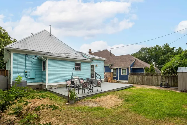 a backyard of a house with table and chairs