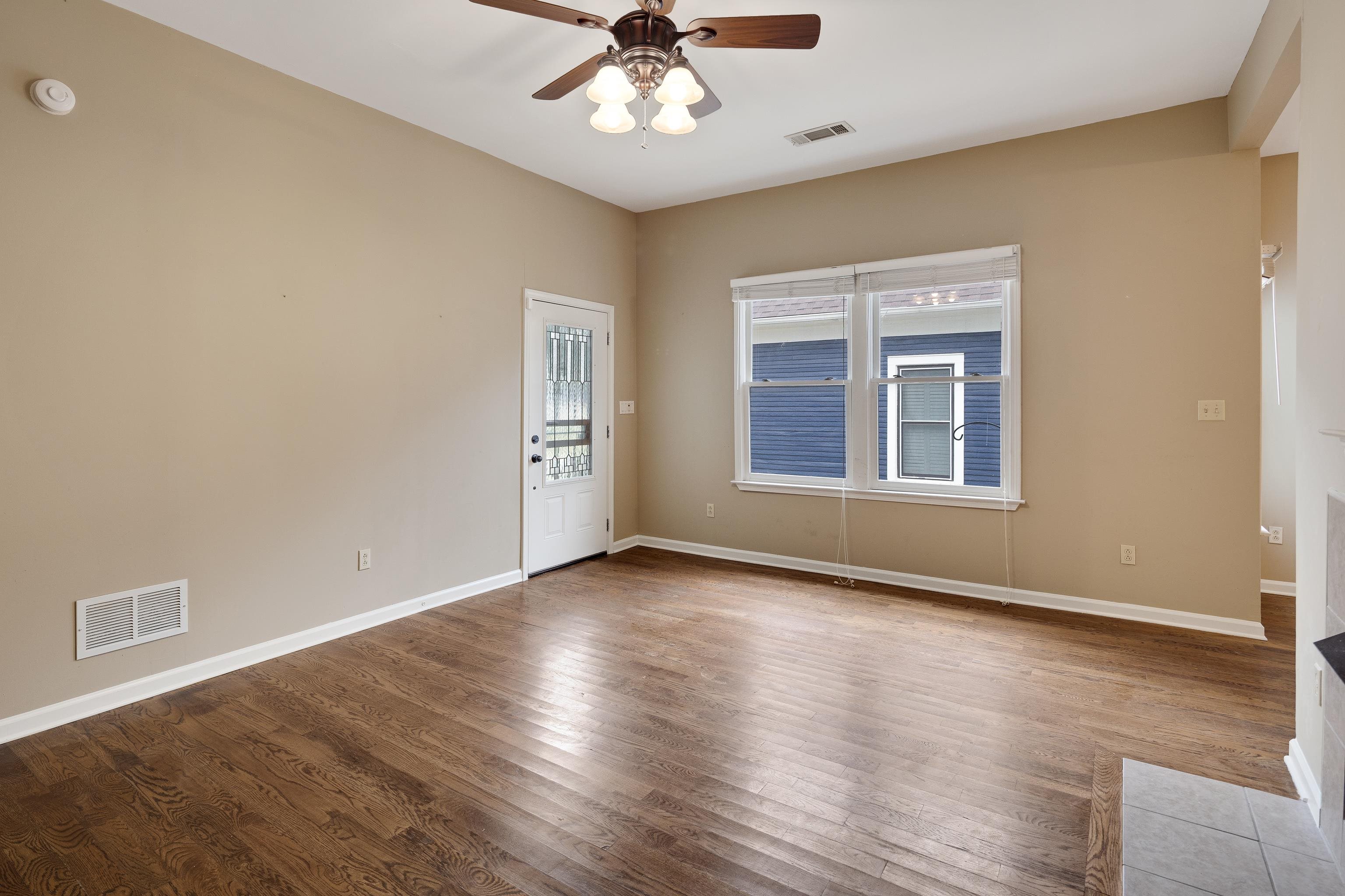 1003 New York Street Memphis, TN 38104 - Photo 7 of 40 an empty room with wooden floor chandelier fan and windows