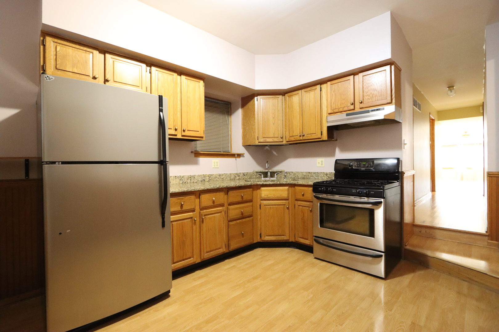 3217 South May Street Chicago, IL 60608 - Photo 13 of 27 a kitchen with granite countertop a refrigerator a sink and a stove