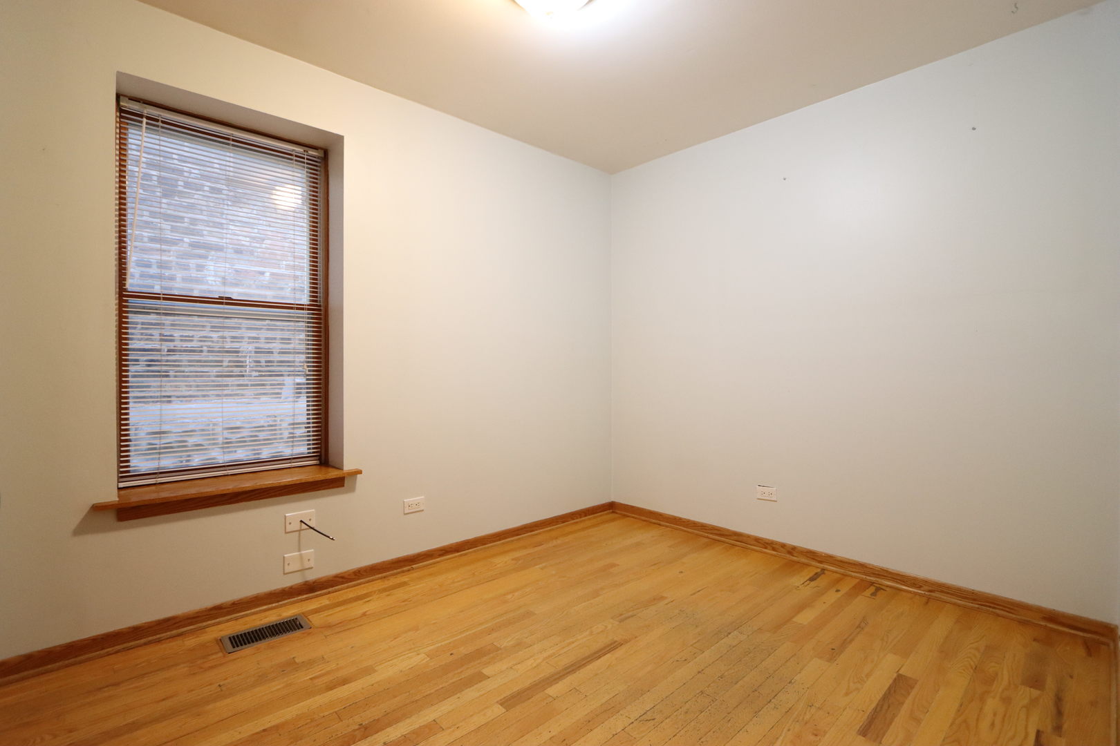 3217 South May Street Chicago, IL 60608 - Photo 16 of 27 an empty room with a wooden floor and windows