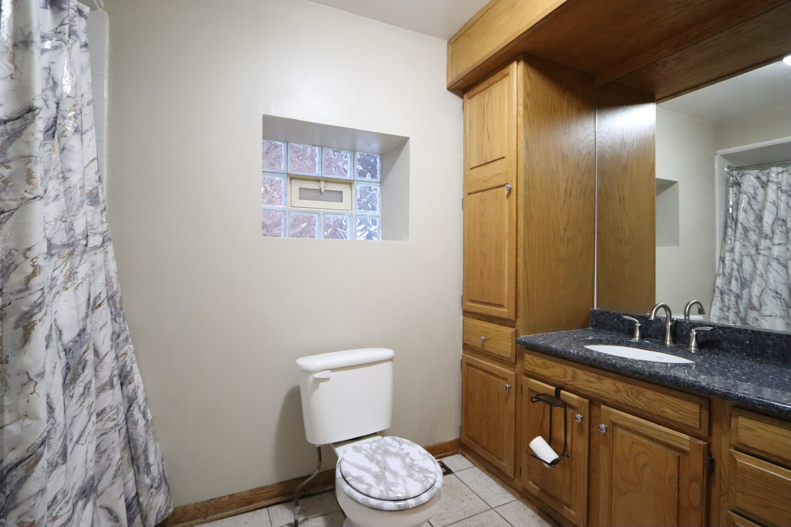 3217 South May Street Chicago, IL 60608 - Photo 19 of 27 a bathroom with a granite countertop sink and a mirror
