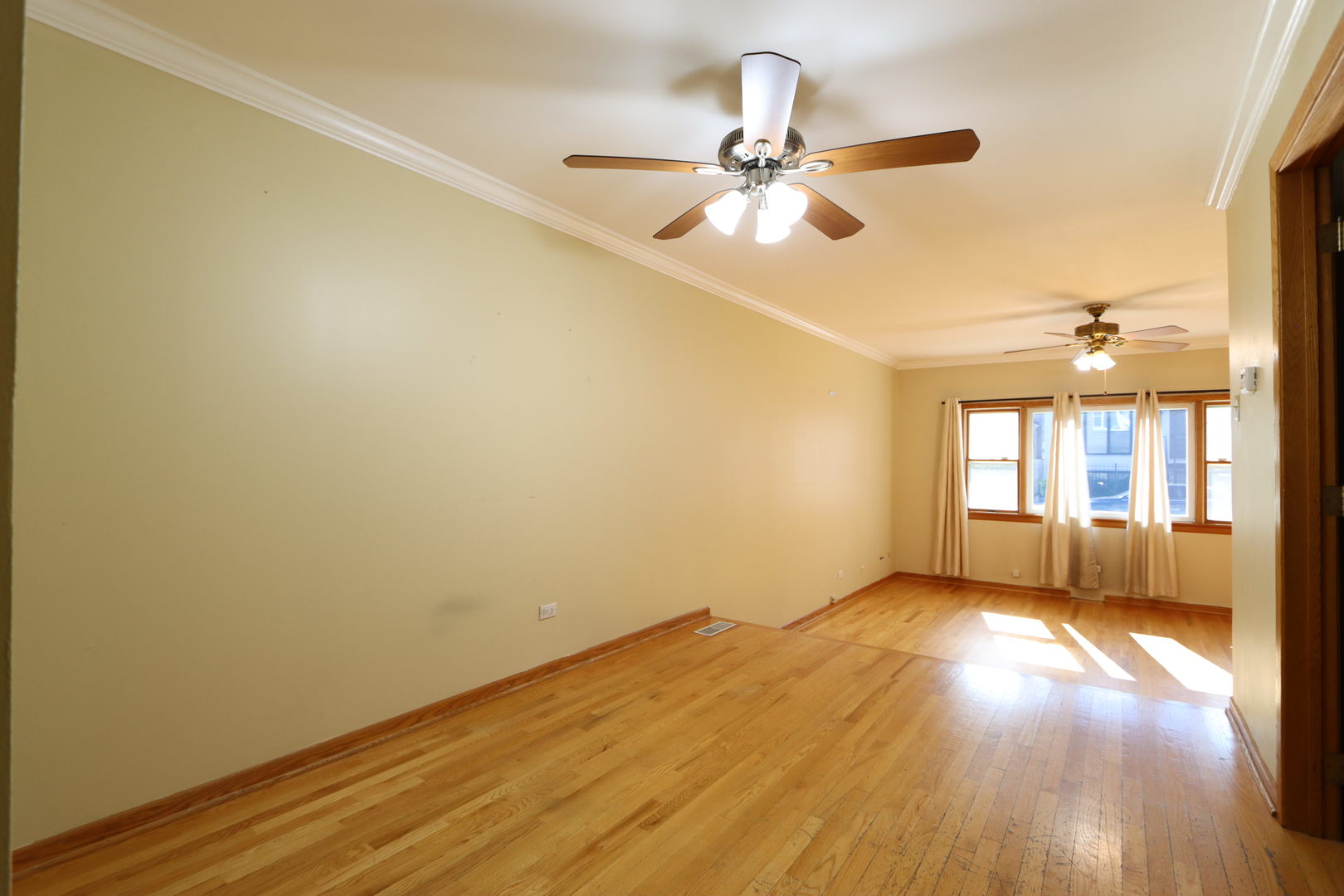 3217 South May Street Chicago, IL 60608 - Photo 5 of 27 a view of empty room with wooden floor and fan