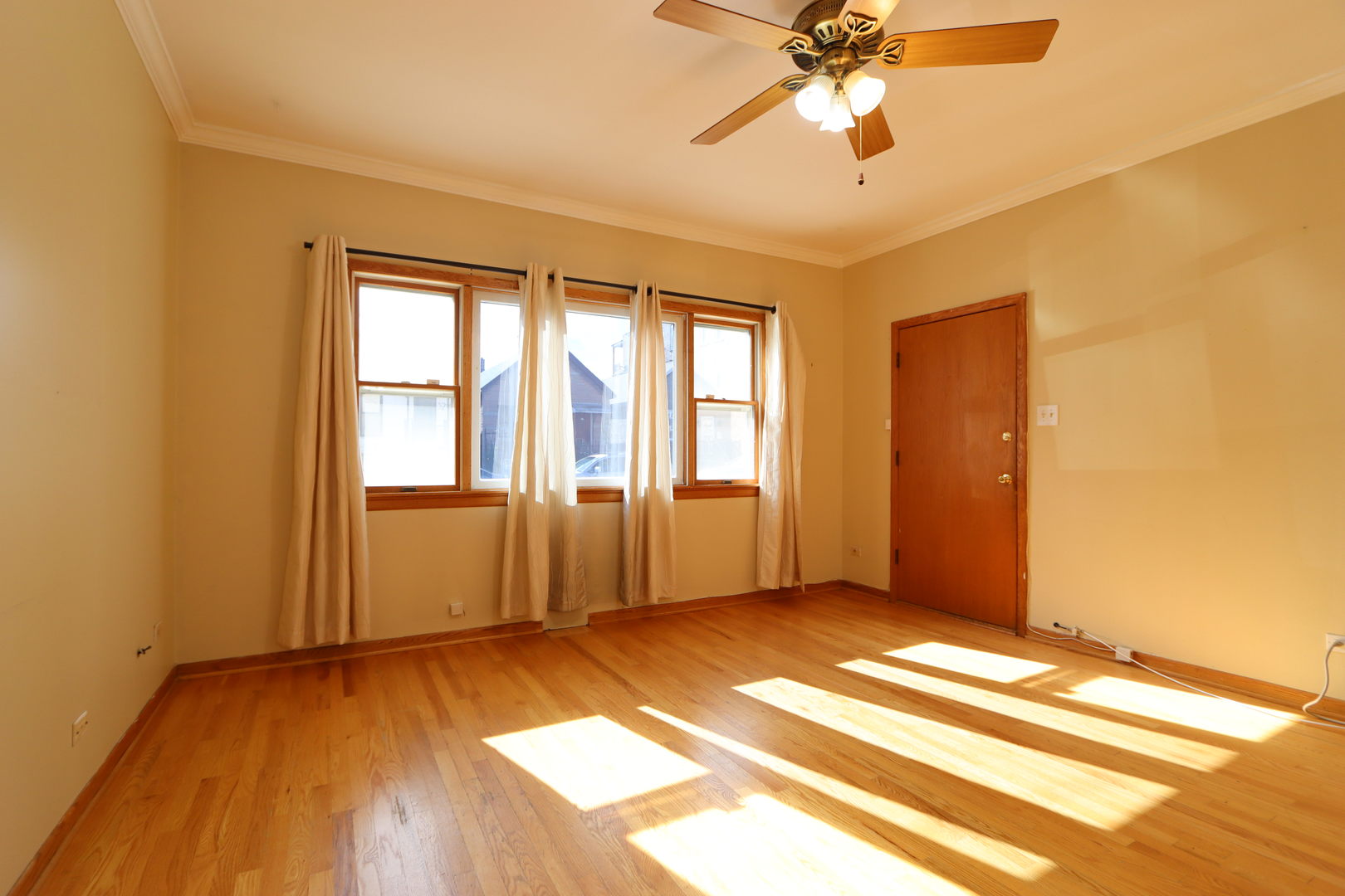 3217 South May Street Chicago, IL 60608 - Photo 6 of 27 a view of empty room with wooden floor and fan