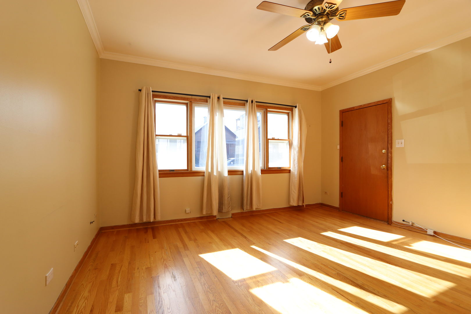 3217 South May Street Chicago, IL 60608 - Photo 9 of 27 a view of an empty room with wooden floor and a window