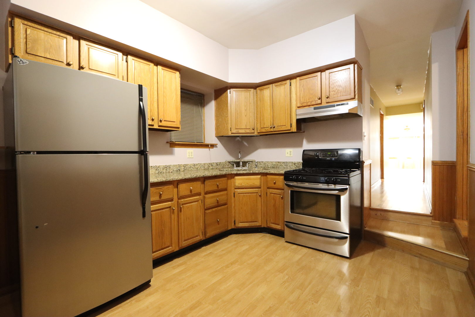 3217 South May Street Chicago, IL 60608 - Photo 10 of 27 a kitchen with granite countertop a refrigerator a stove a sink and a window