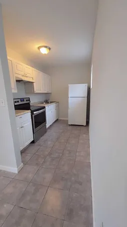 a large white kitchen with a stove a microwave and a refrigerator