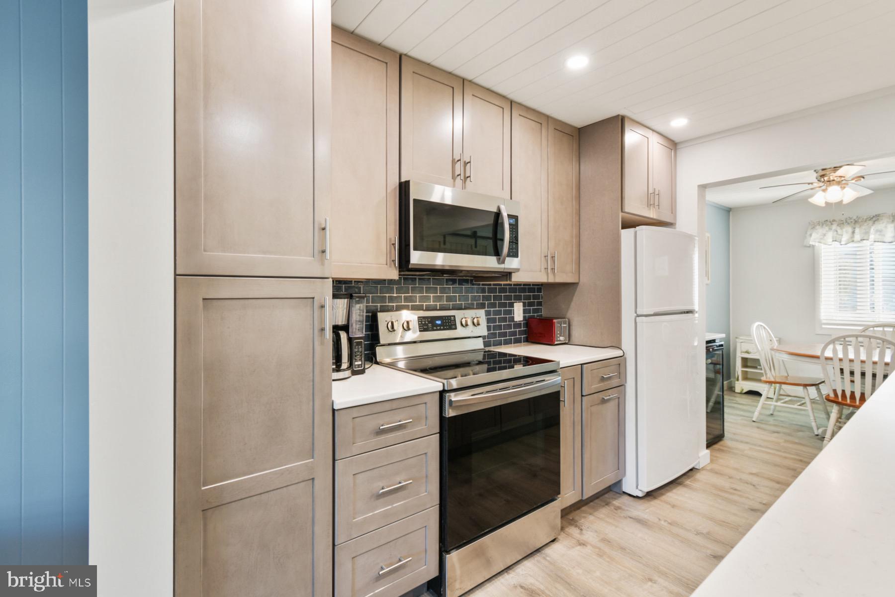 722 Mooring Road, Unit A104 Ocean City, MD 21842 - Photo 6 of 33 a kitchen with cabinets stainless steel appliances and wooden floor