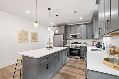 a kitchen with a stove kitchen island and stainless steel appliances