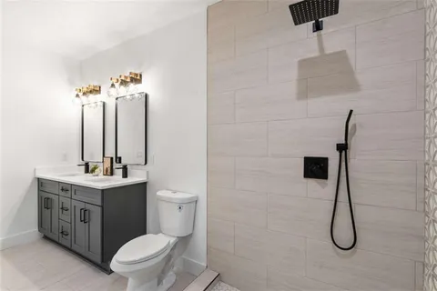 a bathroom with a toilet sink vanity and mirror