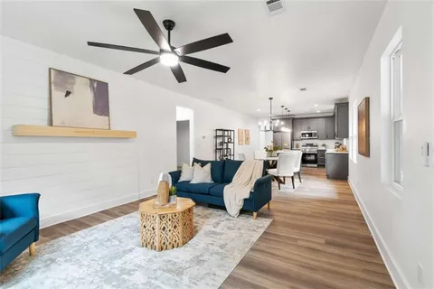 a living room with furniture and a wooden floor