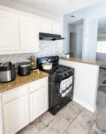 a kitchen with stainless steel appliances granite countertop a stove a sink and a granite counter tops