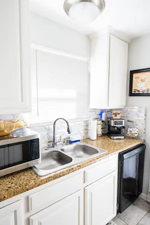 a kitchen with a sink and a stove top oven with wooden floor