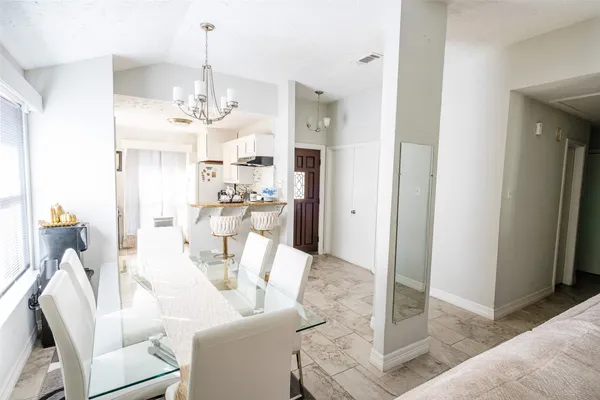 a living room with furniture a chandelier and a dining table